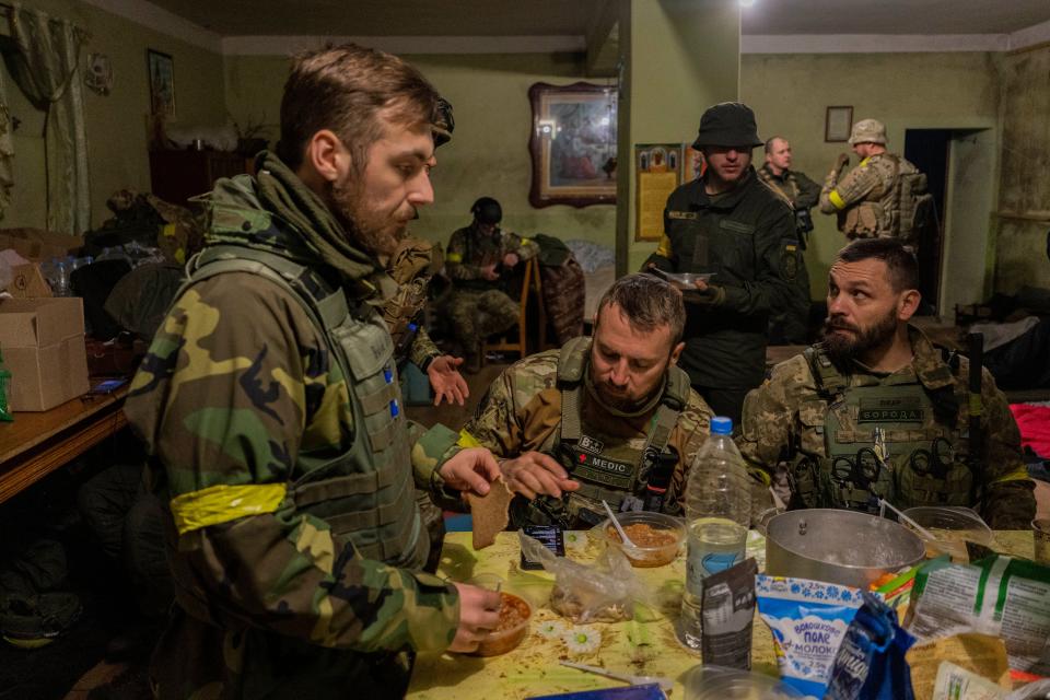 Ukrainian National Guard soldiers gather in a house used as temporary base in a recently retaken village on the outskirts of Kharkiv, east Ukraine, Saturday, May 14, 2022. (AP Photo/Bernat Armangue)