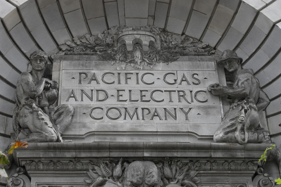 FILE - In this April 16, 2020, file photo, a Pacific Gas & Electric sign is displayed on the exterior of a PG&E building in San Francisco. PG&E's chief financial officer, Jason Wells, is expected to face questions Thursday, May 28 about the company's plan to nearly double its debt to almost $40 billion to finance its payments to wildfire victims, insurers and government agencies in the second day of the company's bankruptcy trial. Meanwhile, the Public Utilities Commission will vote on the bankruptcy plan. (AP Photo/Jeff Chiu, File)