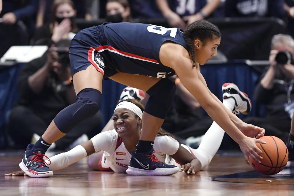 Connecticut's Azzi Fudd, top, reaches for the ball lost by Arkansas' Marquesha Davis, bottom, in the second half of an NCAA college basketball game, Sunday, Nov. 14, 2021, in Hartford, Conn. (AP Photo/Jessica Hill)