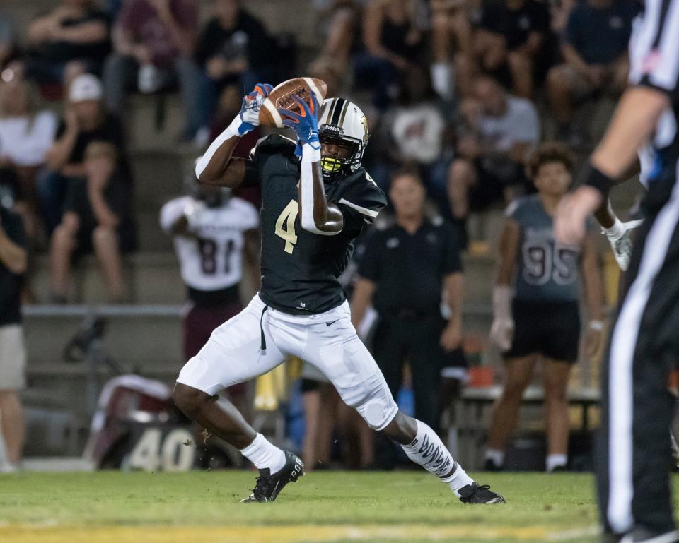 Raymond Cottrell (4) pulls in a pass during the Navarre vs Milton football game at Milton High School on Friday, Sept. 10, 2021.
