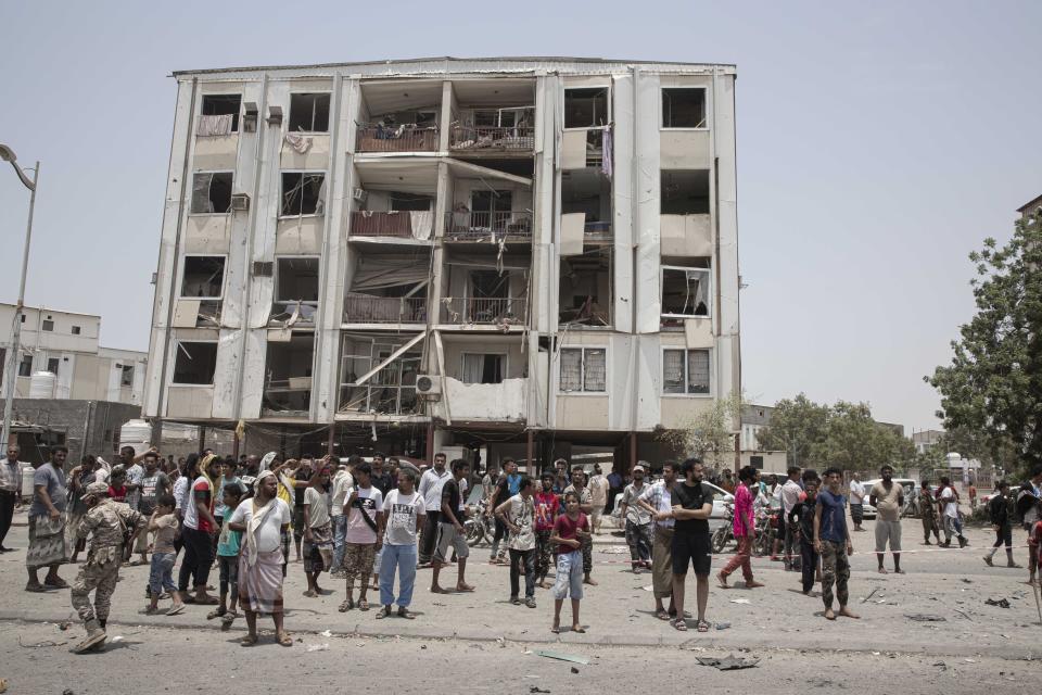 People gather at the site of a deadly attack on the Sheikh Othman police station, in Aden, Yemen, Thursday, Aug. 1, 2019. Yemen's rebels fired a ballistic missile at a military parade Thursday in the southern port city of Aden as coordinated suicide bombings targeted the police station in another part of the city. The attacks killed over 50 people and wounded dozens. (AP Photo/Nariman El-Mofty)