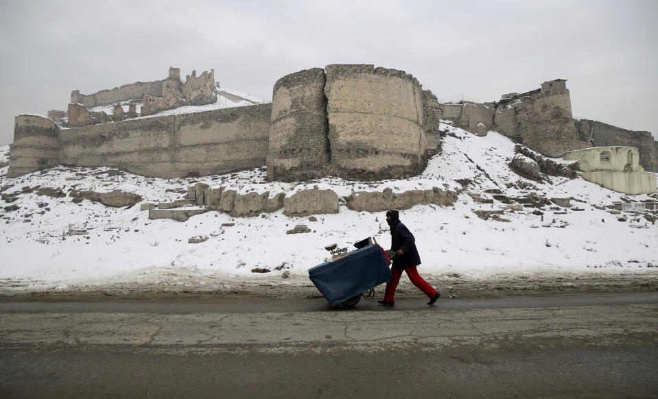 An Afghan street vendor pulls his hand cart after a heavy snowfall in Kabul, Afghanistan, Tuesday, Jan. 14, 2020. Severe winter weather has struck parts of Afghanistan and Pakistan, with heavy snowfall, rains and flash floods that left dozens 40 dead, officials said Monday as authorities struggled to clear and reopen highways and evacuate people to safer places. (AP Photo/Rahmat Gul)