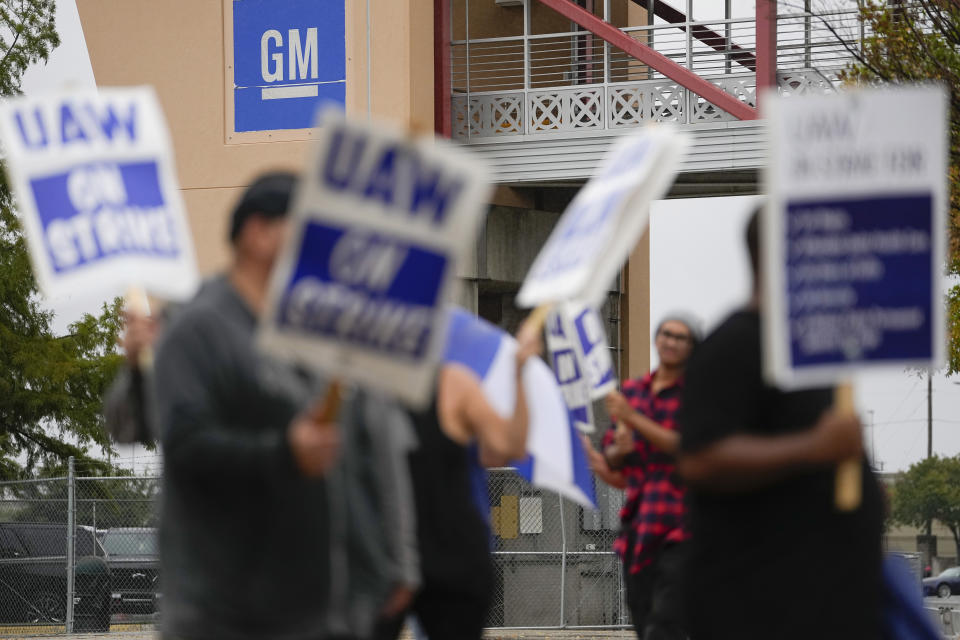 Picketers strike outside of the General Motors assembly plant, Tuesday, Oct. 24, 2023, in Arlington, Texas. The United Auto Workers union is turning up the heat on General Motors as 5,000 workers walked off their jobs at a highly profitable SUV factory. (AP Photo/Julio Cortez)