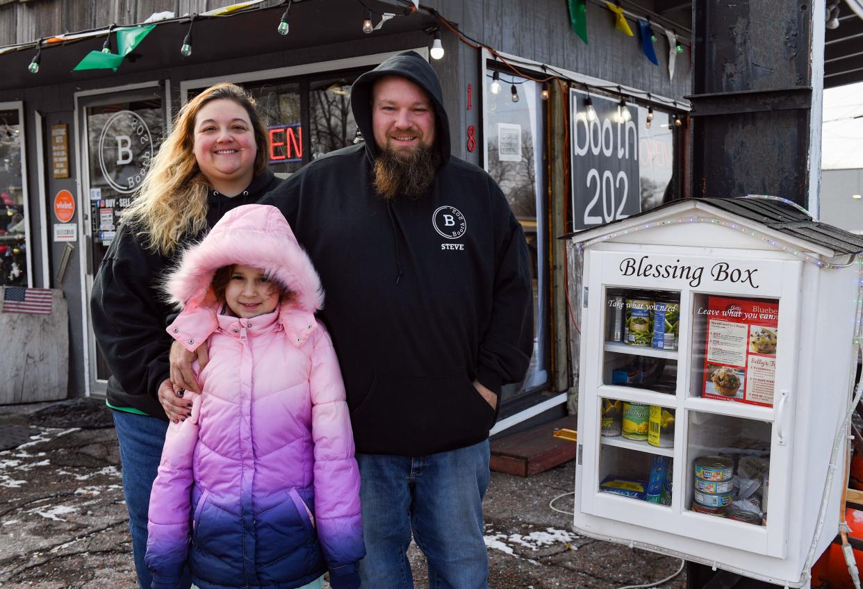 Marie Murfin, Steve Whitman and their 8-year-old daughter, Lily Whitman, stand for a photo with the Blessing Box, an anonymous food donation setup, on Saturday, December 18, 2021 at their antique shop, Booth 202, in Sioux Falls. 
