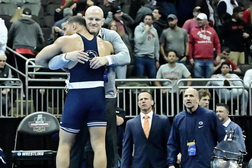 Penn State’s Aaron Brooks embraces coach Cael Sanderson on Saturday night at the T-Mobile Center in Kansas City, Mo. Brooks defeated N.C. State’s Trent Hidlay 6-1 to become the second Penn State wrestler (after Carter Starocci) to ever win four national titles.