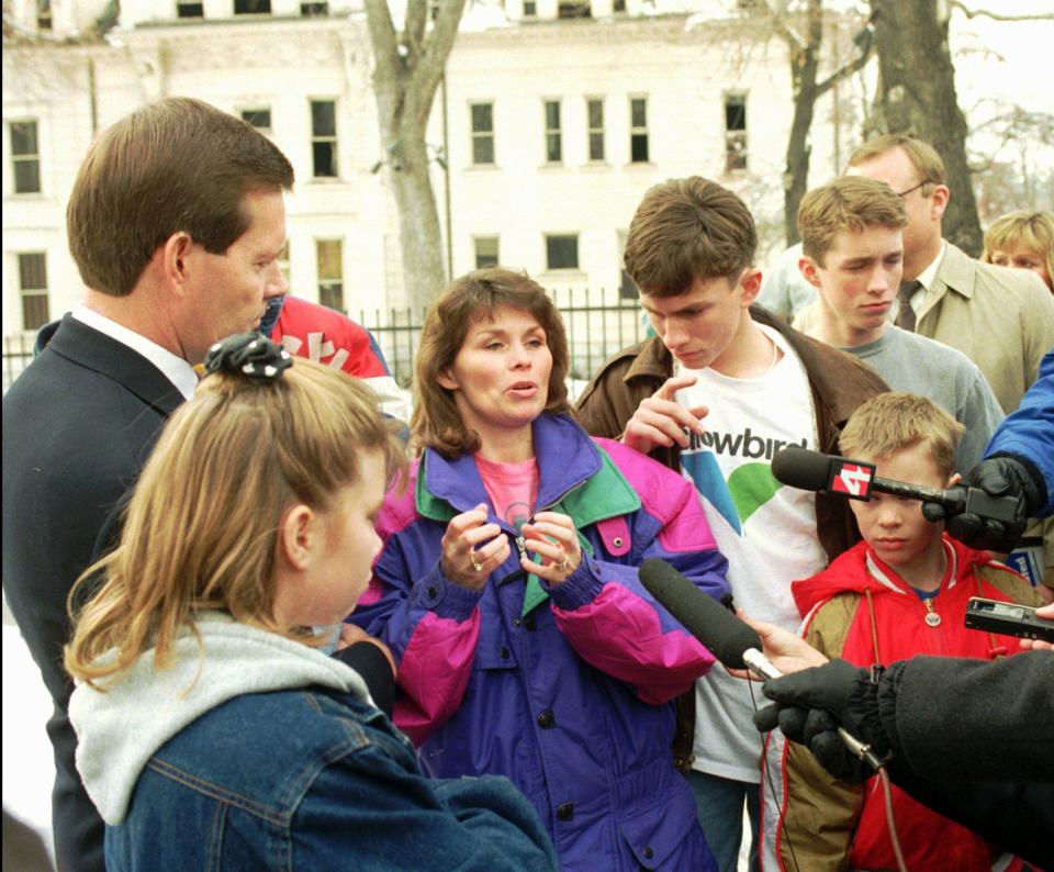 With the damaged Governor’s Mansion in the background, Utah Gov. Mike Leavitt and his family meet with the press after the fire there two hours before. Here, Jacalyn Leavitt, who was in the home at the time of the fire, explains the trouble they had trying to get out of the house. The fire created a backdraft that made the doors very difficult to open. With some help, all got out safely. | Gerald W. Silver, Deseret News