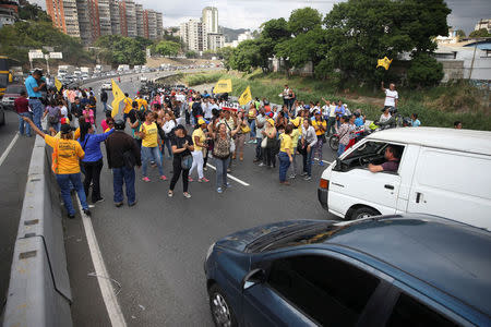 Opposition supporters shout slogans as they block a highway during a protest against Venezuelan President Nicolas Maduro's government in Caracas. REUTERS/Carlos Garcia Rawlins