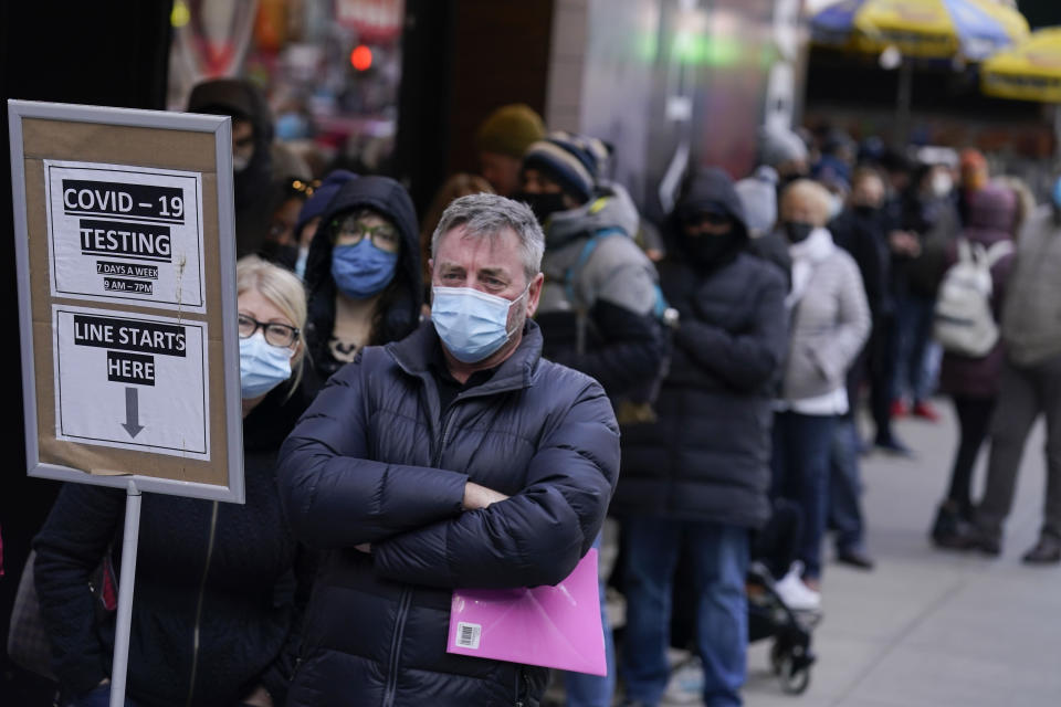 FILE - People wait in line at a COVID-19 testing site in Times Square, New York, Monday, Dec. 13, 2021. The U.S. death toll from COVID-19 topped 800,000, a once-unimaginable figure seen as doubly tragic, given that more than 200,000 of those lives were lost after the vaccine became available practically for the asking. (AP Photo/Seth Wenig, File)