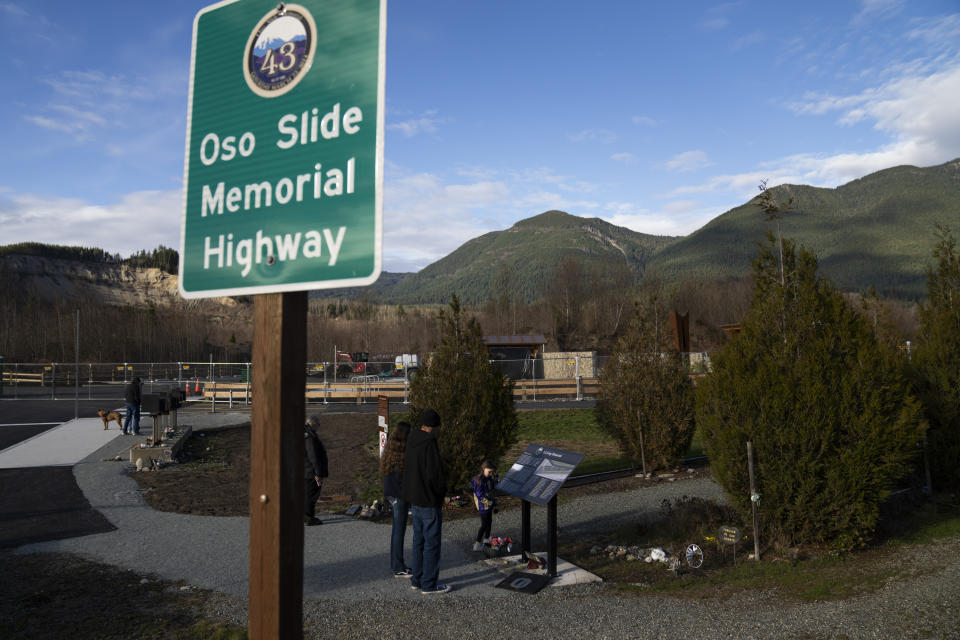 People visit the site of the Oso landslide on Saturday, Feb. 17, 2024, in Oso, Wash. The trauma that engulfed Oso, a rural community of a couple hundred residents, on March 22, 2014, was a national wake-up call about the dangers of landslides. (AP Photo/Jenny Kane)