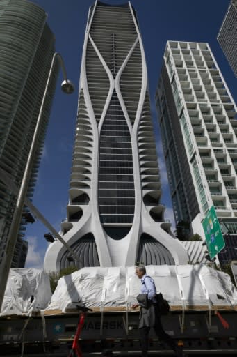 The building has a unique curving "exoskeleton" made of white fiberglass-reinforced concrete
