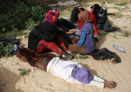 A dehydrated and exhausted African migrant lies in the ground after being detained in Zawiya, northern Libya June 1, 2014. Reuters/Ahmed Jadallah