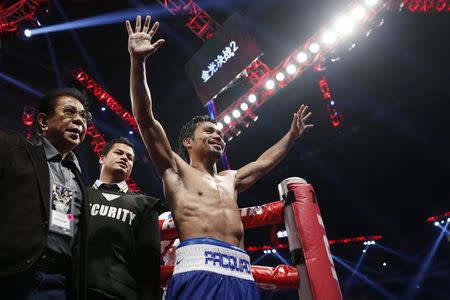 Manny Pacquiao of the Philippines celebrates his victory over Chris Algieri of the U.S. during their World Boxing Organisation (WBO) 12-round welterweight title fight at the Venetian Macao hotel in Macau November 23, 2014. REUTERS/Tyrone Siu