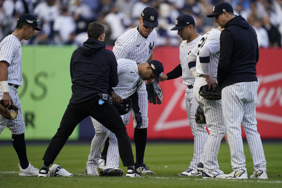 New York Yankees center fielder Aaron Hicks is helped up after colliding with Oswaldo Cabrera during the third inning of Game 5 of an American League Division baseball series against the Cleveland Guardians, Tuesday, Oct. 18, 2022, in New York. (AP Photo/John Minchillo)