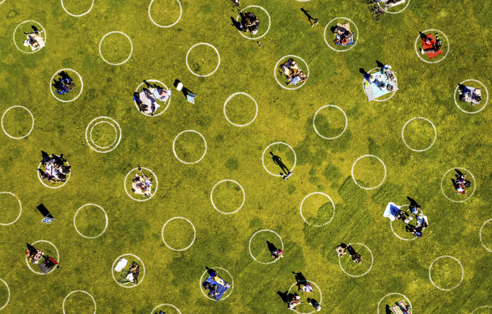 FILE - In this May 21, 2020, file photo, people in San Francisco's Dolores Park sit inside painted circles designed to help them keep a healthy distance to prevent the spread of the coronavirus. A new analysis published in the journal Lancet on Monday, June 1, 2020, provides reassurance that masks and social distancing help but hand washing and other measures are still needed to control the coronavirus. (AP Photo/Noah Berger, File)