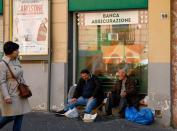 Men beg on the street in Naples