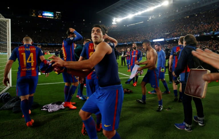 Barcelona forward Luis Suarez prepares to throw his shirt to the fans as he celebrates their 6-1 victory in the Champions League round of 16 second leg against Paris Saint-Germain FC at the Camp Nou stadium in Barcelona on March 8, 2017