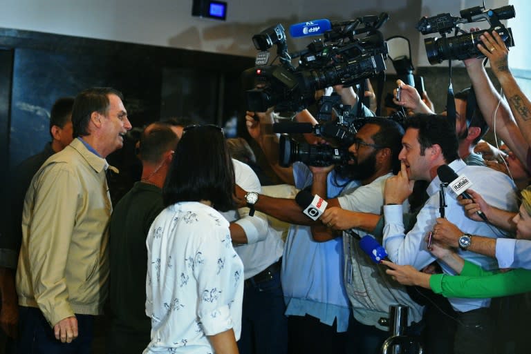 Brazilian far-right presidential candidate Jair Bolsonaro (C) speaks to the press during a visit to the Federal Police station in Rio de Janeiro, Brazil