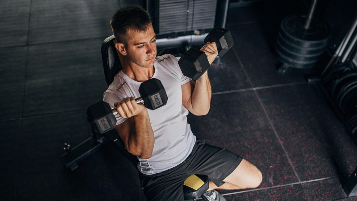  Man doing seated bicep curls. 