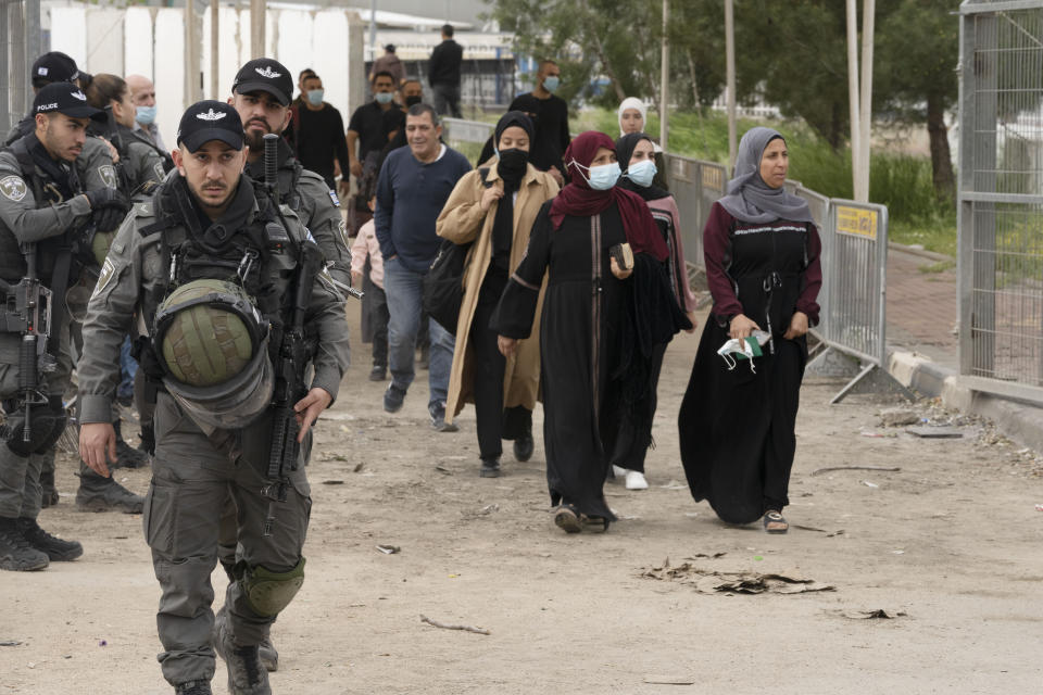 Israeli Border Police secure the exit to a checkpoint from the West Bank town of Bethlehem into Jerusalem as Palestinians cross for the first Friday prayers in the Muslim holy month of Ramadan at the Al Aqsa mosque compound in Jerusalem's Old City, Friday, April 8, 2022. (AP Photo/Maya Alleruzzo)