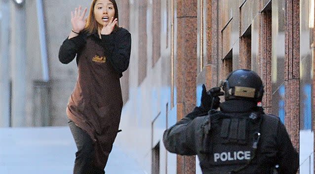 Sydney Siege hostage Elly Chen runs from the Lindt Chocolate cafe in Martin Place on December 15, 2014. Photo: AAP