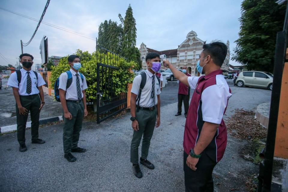 Students have their temperature taken at Sekolah Menengah Kebangsaan Methodist (ACS), Ipoh  January 20, 2021. — Picture by Farhan Najib