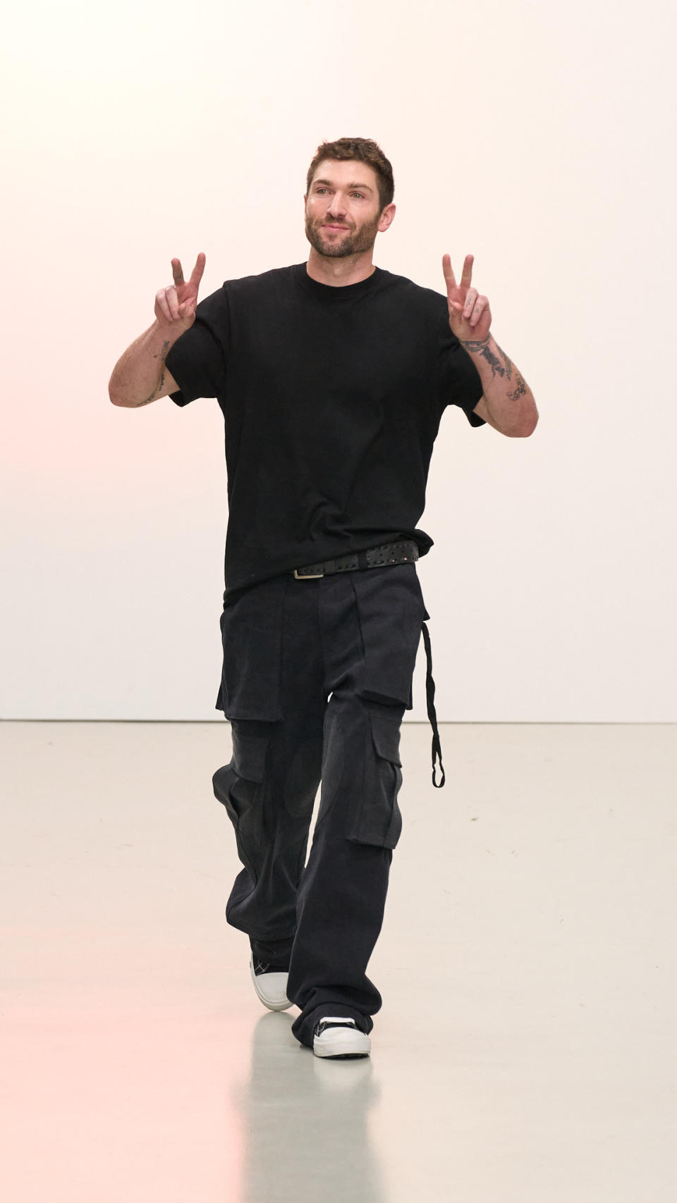 Self-taught designer Doni Nahmias takes a bow in Paris following his spring 2023 show. - Credit: Courtesy of Nahmias