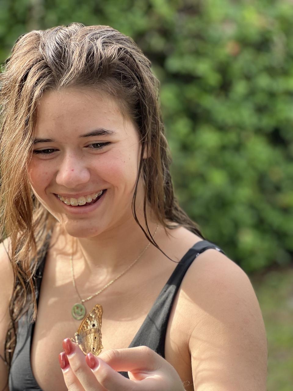 A family photo shows Lilly Glaubach with a butterfly resting on her hand after she rescued it from the lanai at her home in Osprey. 