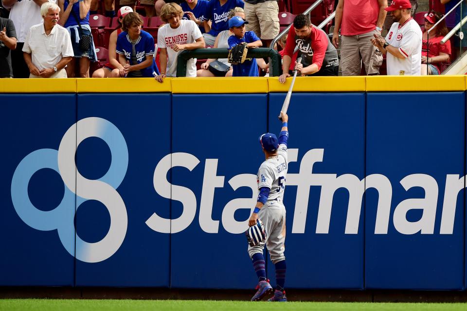 Dodgers outfielder Mookie Betts  gives the fan who caught the first major league hit and home run ball by Reds outfielder TJ Friedl a bat in exchange for the ball.