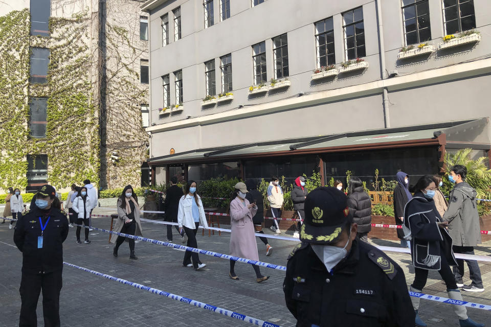 Residents line up for mass testing in a lockdown area in the Jingan district of western Shanghai, Monday, April 4, 2022. China has sent more than 10,000 health workers from across the country to Shanghai, including 2,000 military medical staff, as it struggles to stamp out a rapidly spreading COVID-19 outbreak in China's largest city. (AP Photo/Chen Si)