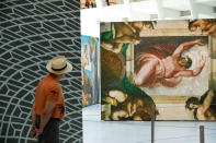 <p>A man views replicas of Michelangelo’s Sistine Chapel frescoes inside of the Oculus at the World Trade Center Transportation Hub in New York City. The exhibit contains 34 nearly life-size copies of the frescoes. (Photo by Drew Angerer/Getty Images) </p>