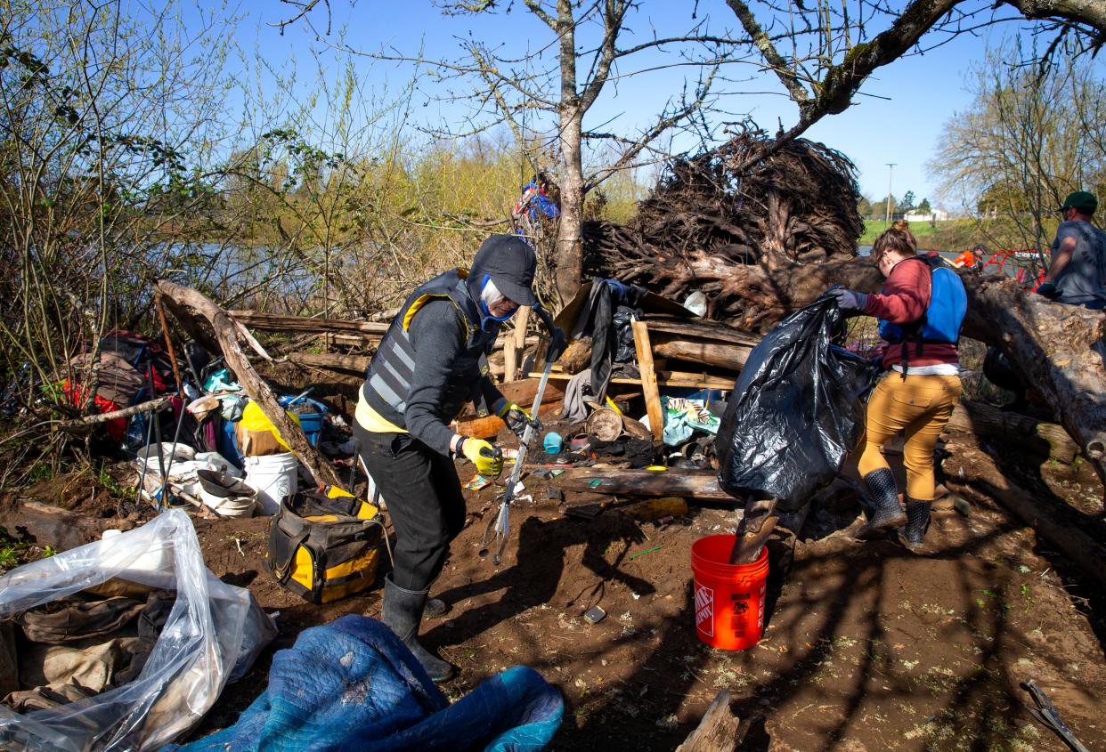 Willamette Riverkeeper members Daphne Mantis, left, and Sarah Dunn join a dozen other volunteers in clearing garbage from a camp on an island in the middle of the Willamette River south of Beltline in Eugene.