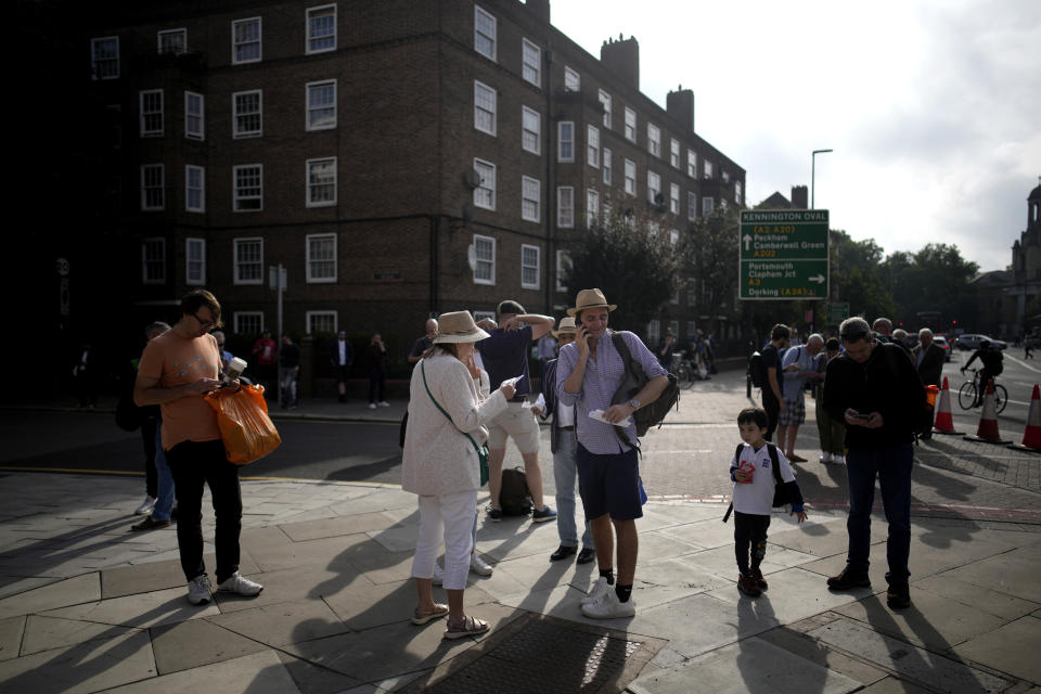 People wait to enter the Oval cricket ground for the cricket test match against England and South Africa in London, Sunday, Sept. 11, 2022. On morning television, the moment was singularly somber — the departure of the hearse bearing the flag-draped coffin of Queen Elizabeth II. But at the very same hour, as fans in shorts and Ray-Bans streamed into London's Oval stadium for a long-anticipated cricket match, you wouldn't have guessed the country was preparing for the most royal of funerals. (AP Photo/Christophe Ena)