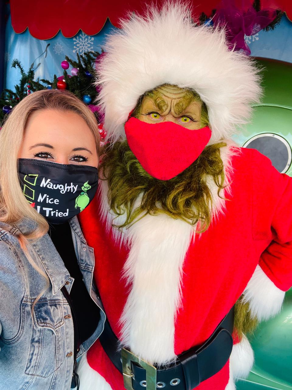 The writer wearing a mask next to someone dressed up as the Grinch wearing a mask