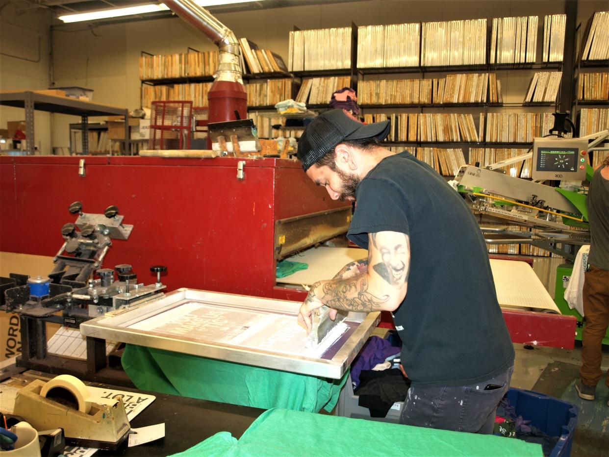 Matt Graves prepares to print a T-shirt for Raygun, the self-proclaimed "Greatest Store in the Universe." The printing, design and clothing store in Des Moines' East Village makes its own catchy ― and often snarky ― products locally.