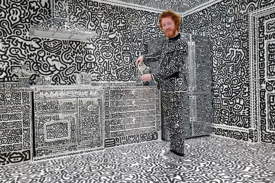 Mr Doodle wearing an outfit covered in doodles in his kitchen.