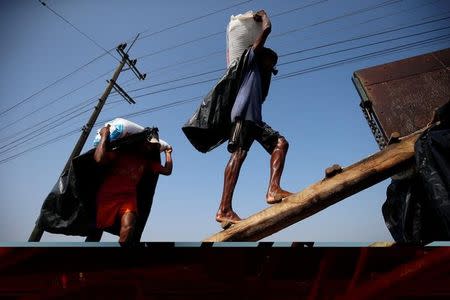 Rohingya refugee workers carry bags of salt as they work in processing yard in Cox's Bazar, Bangladesh. Picture taken on April 12, 2017. REUTERS/Mohammad Ponir Hossain/Files