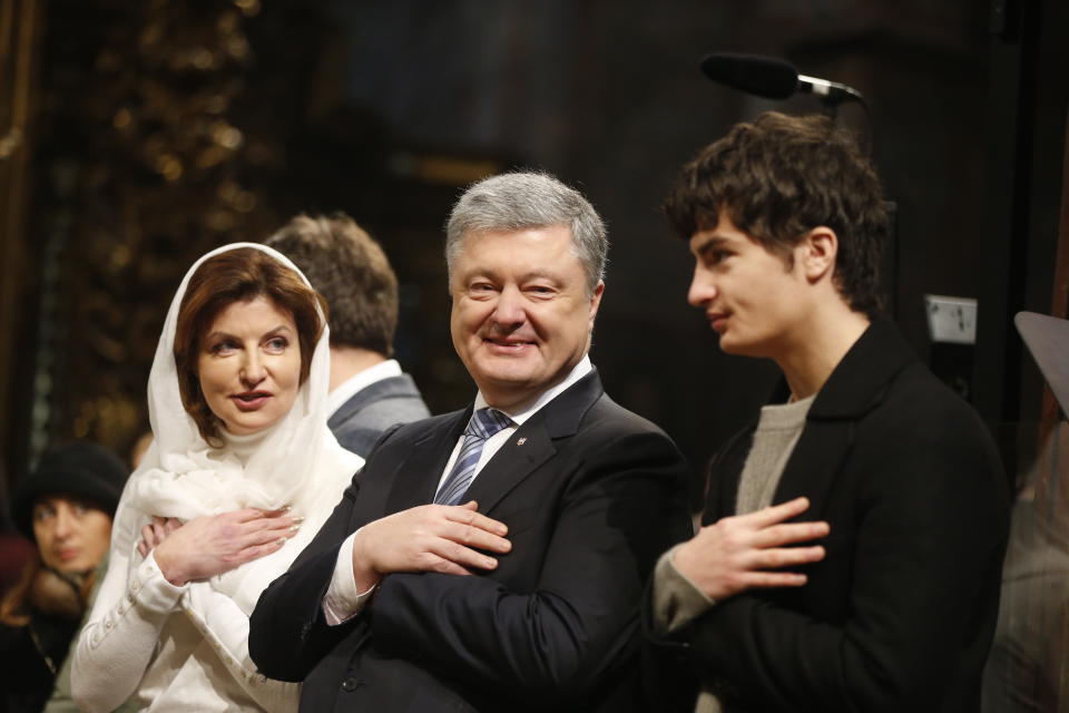 Ukrainian President Petro Poroshenko, center, his wife Maryna, left, and his son, right, attend the service marking Orthodox Christmas and celebrating independence of Ukrainian Orthodox Church in the St. Sophia Cathedral in Kiev, Ukraine, Monday, Jan. 7, 2019. (AP Photo/Efrem Lukatsky)