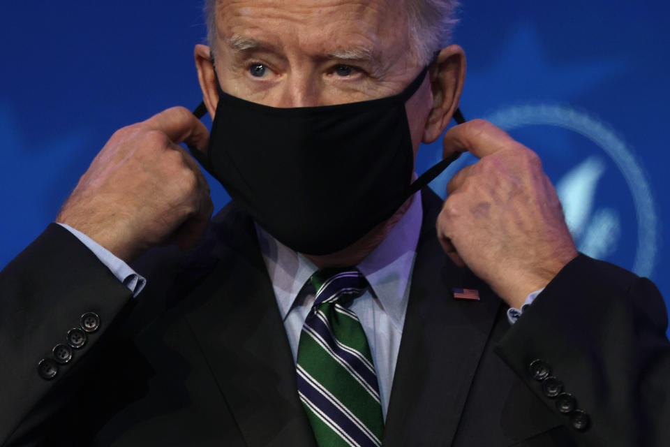 U.S. President-elect Joe Biden takes his mask off prior to an announcement January 16, 2021 at the Queen theatre in Wilmington, Delaware