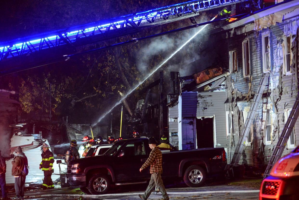 Firefighters work to extinguish a fire in a building after a single-engine plane crashed nearby in Keene, N.H., Friday, Oct. 21, 2022. 