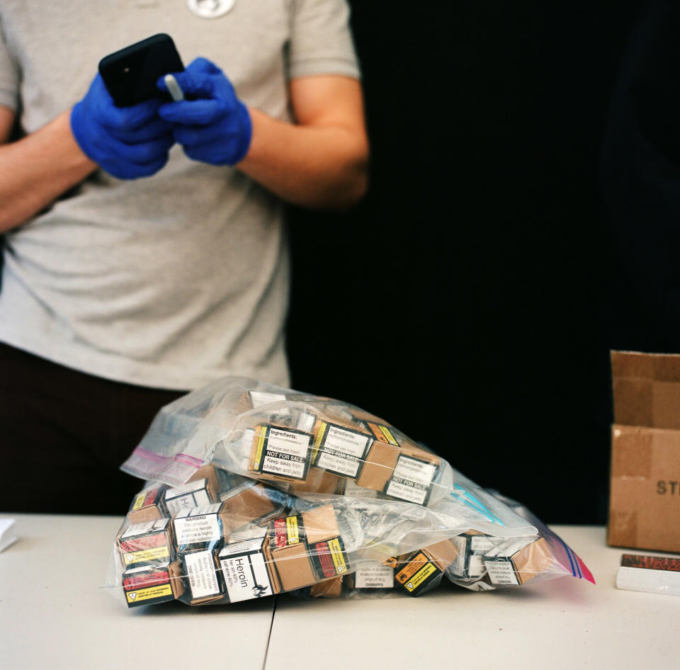 A member of the Drug User Liberation Front hands out illegal drugs that have been tested and determined to be free of fentanyl, then packaged and given warning labels similar to those on cigarette packs, at an event on April 14, 2021.<span class="copyright">Jackie Dives</span>