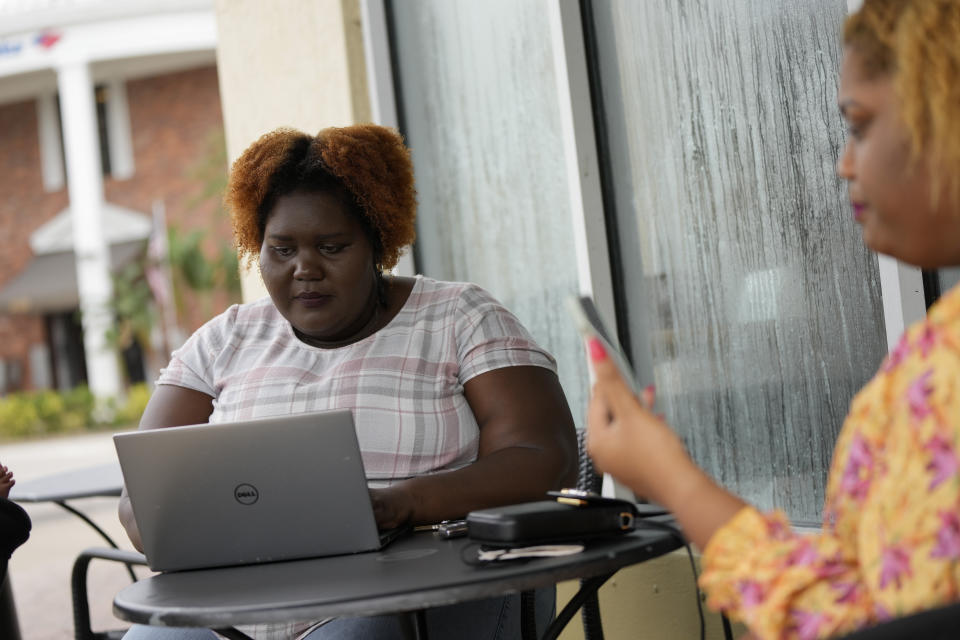 Francesca Menes, left, and Krystina Francois, children of Haitian immigrants to the U.S. and co-founders of the Black Collective, work together outside a Starbucks, Tuesday, Sept. 21, 2021, in Miami Shores, Fla. Menes and Francois, whose advocacy organization focuses on the political needs and economic empowerment of Black people across the African diaspora, have called for the Biden administration to immediately suspend plans to remove migrants via planes bound for Haiti. (AP Photo/Rebecca Blackwell)