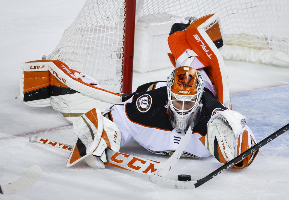 Anaheim Ducks goalie Lukas Dostal dives for the puck during third-period NHL hockey game action against the Calgary Ducks in Calgary, Alberta, Sunday, April 2, 2023. (Jeff McIntosh/The Canadian Press via AP)