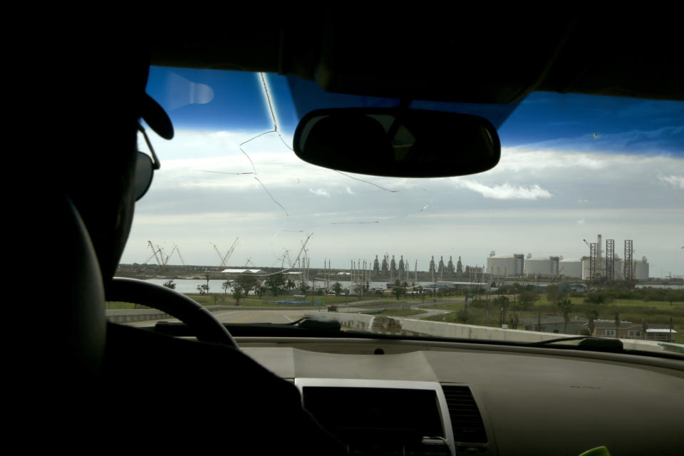 John Beard drives near a liquid natural gas facility in Port Arthur, Texas, on Wednesday, Oct. 27, 2021. It is one of several LNG facilities along the Gulf Coast. As the United States produces more natural gas, increasingly, it is being exported to Asia, Europe and other places. Beard, head of the Port Arthur Community Action Network, says Black and brown communities like Port Arthur are having to bear much of the risk posed by facilities like these, from explosion to impact on air quality. In addition to LNG facilities, Port Arthur is also surrounded by oil refineries and petrochemical plants. "Port Arthur's what's called the American Sacrifice Zone," Beard said. (AP Photo/Martha Irvine)