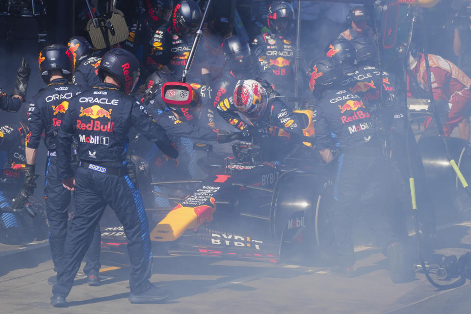 Mechanics work to extinguish a fire in Red Bull driver Max Verstappen of the Netherlands' car during the Australian Formula One Grand Prix at Albert Park, in Melbourne, Australia, Sunday, March 24, 2024. (AP Photo/Scott Barbour,Pool)