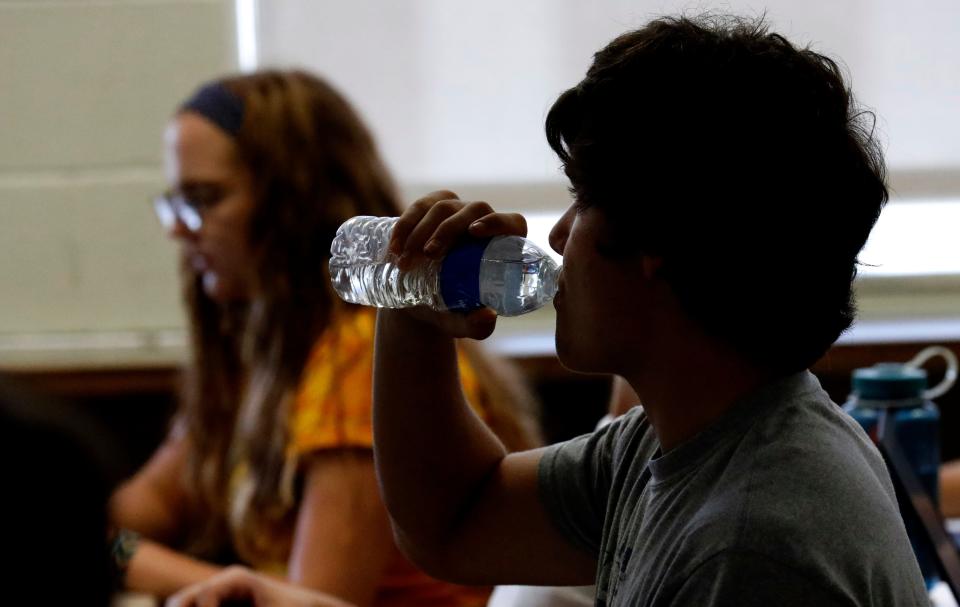 A student takes a drink of water during a statistics class Wednesday, Sept. 5, 2018, at Lancaster High School in Ohio.  The school was built with no air conditioning and on hot days, temperatures can be in the upper 80s in the hottest classrooms.