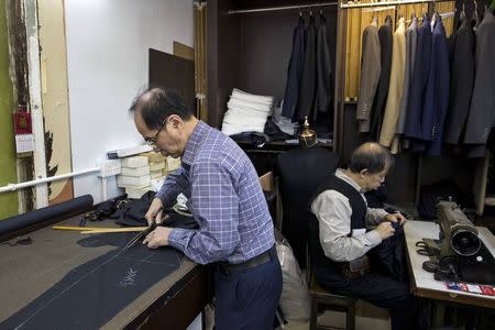 Tailors work at a workshop at Hong Kong's Tsim Sha Tsui shopping district January 22, 2015. REUTERS/Tyrone Siu