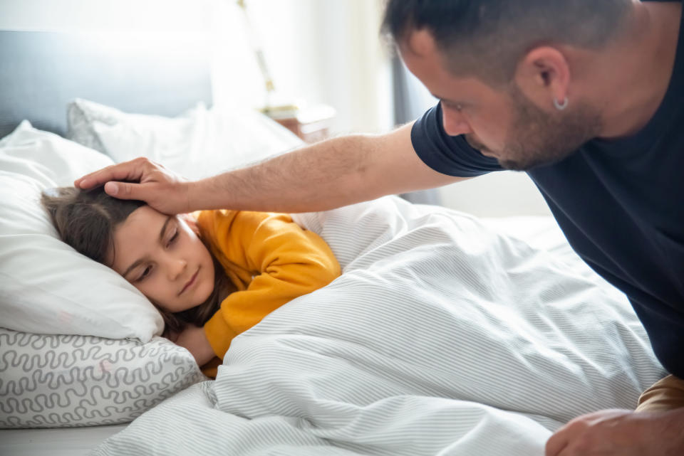 a man comforting a sick child