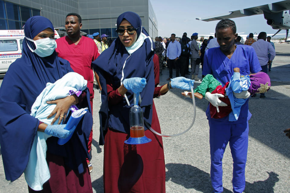 Medical personnel carry wounded children to be airlifted to the Turkish capital for treatment after they were injured in Saturday's car bomb blast in Mogadishu, Somalia, Sunday, Dec. 29, 2019. A truck bomb exploded at a busy security checkpoint in Somalia's capital Saturday morning, killing at least 79 people including many students, authorities said. It was the worst attack in Mogadishu since the devastating 2017 bombing that killed hundreds. (AP Photo/Farah Abdi Warsameh)