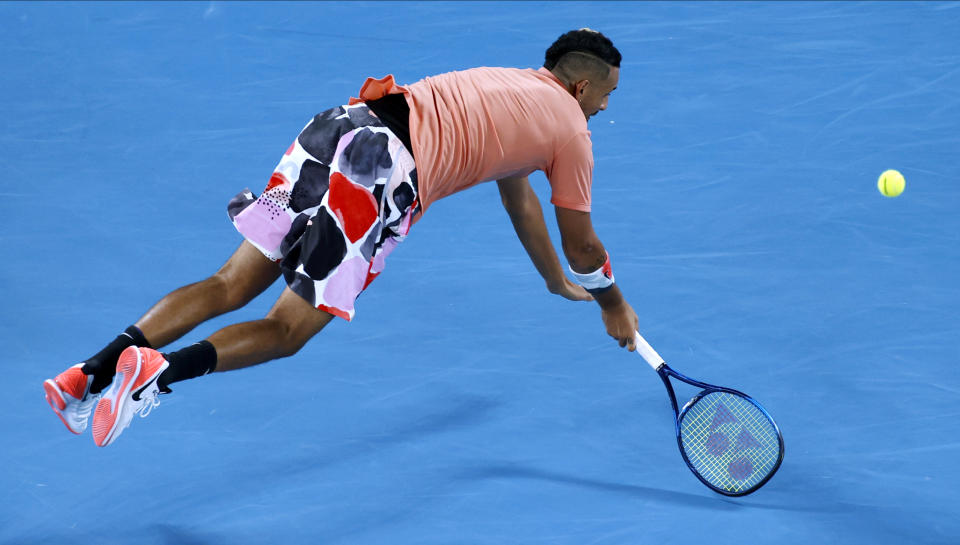 Australia's Nick Kyrgios is airborne as he attempts to return a shot to Spain's Rafael Nadal during their fourth round singles match at the Australian Open tennis championship in Melbourne, Australia, Monday, Jan. 27, 2020. (AP Photo/Andy Wong)