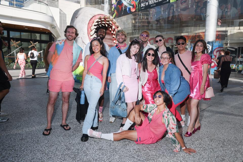 A group of friends pose for a portrait dressed as characters in "Barbie" outside a movie theater where "Barbie" is playing at AMC Century City on Friday, July 21, 2023 in Los Angeles, CA.